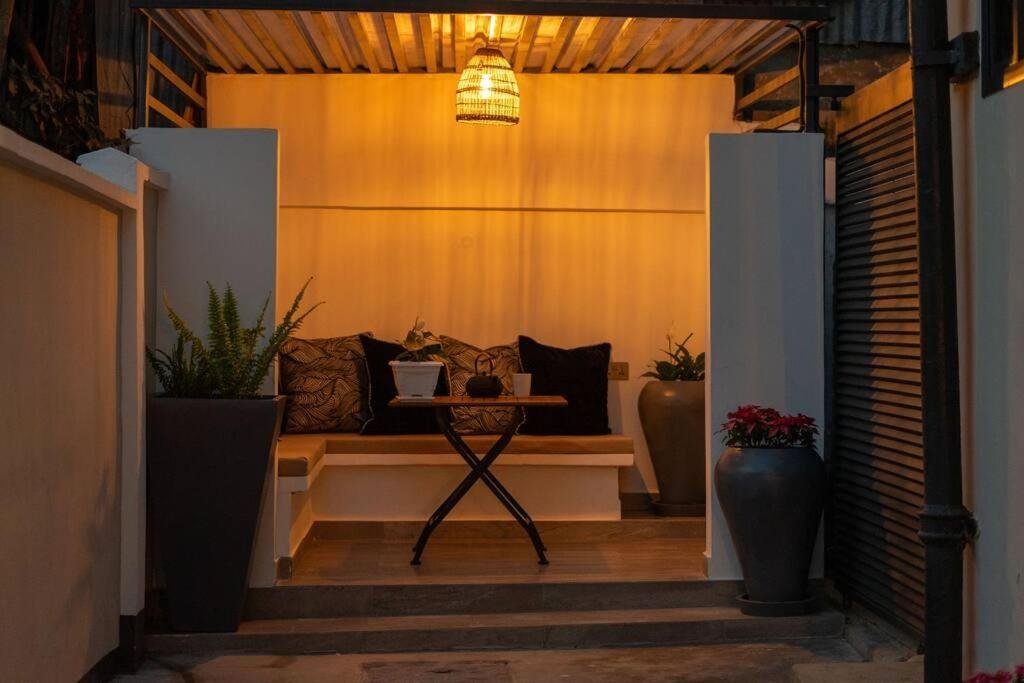 Family-Friendly 2BR: covered outdoor seating nook at dusk