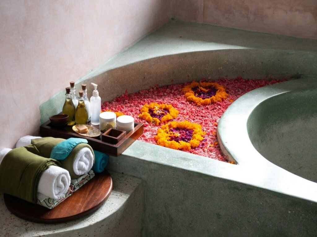 Spa bathtub filled with flower petals and bath products